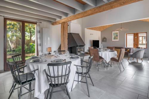 une salle à manger avec tables et chaises et une cuisine dans l'établissement Maison avec dépendance pour 11 à 800m de la mer, à La Plaine-sur-Mer
