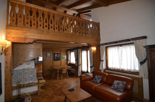 a living room with a couch and a staircase at Holidays on Dolomites in Villanova