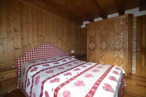 a bedroom with a bed with a red and white blanket at Holidays on Dolomites in Villanova