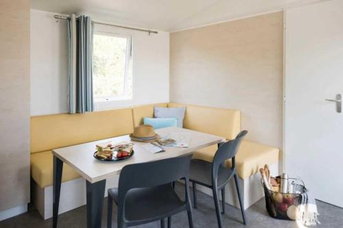 une petite salle à manger avec une table et des chaises dans l'établissement Camping 3 étoiles - Piscine - ccb0dii, à Vias