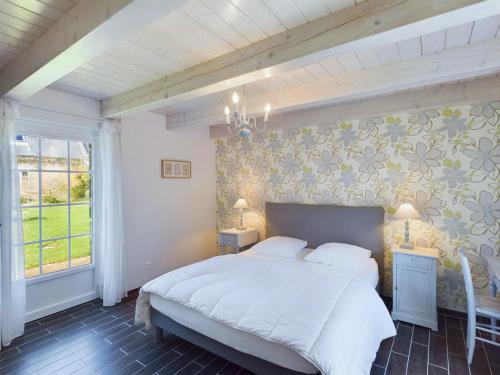 une chambre avec un grand lit blanc et une fenêtre dans l'établissement Charmante maison pour 5 à Plovan, à Plovan