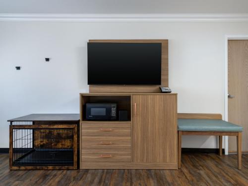 a entertainment center with a flat screen tv and a chair at Holiday Inn Resort The Squire at Grand Canyon by IHG in Tusayan