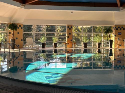 a swimming pool in a building with a large window at Siedlisko Żurawie in Zamarte