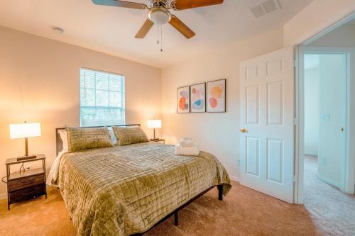 a bedroom with a bed and a ceiling fan at Full House HotTub Mins to UCF in Bithlo