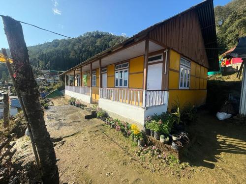 a yellow house with flowers in front of it at The Nature Homestay in Pedong