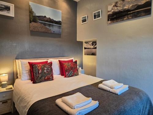 a bedroom with a bed with two towels on it at Herdwick Guest House in Keswick