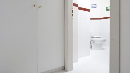 a white bathroom with a toilet in a room at Italianway - Dogana 3 in Milan