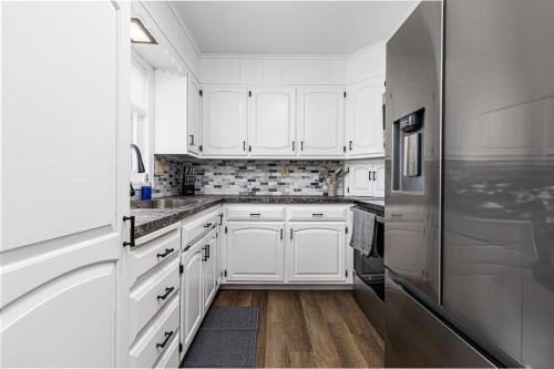 a white kitchen with white cabinets and a refrigerator at Serenity Inn in Ronks