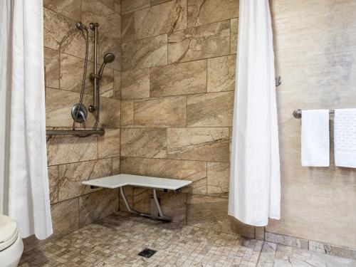 a bathroom with a shower with a bench in it at Holiday Inn Resort The Squire at Grand Canyon by IHG in Tusayan