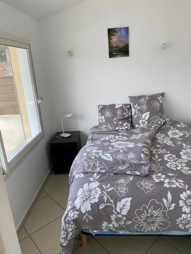 - une chambre avec un lit doté d'une couette grise et d'une fenêtre dans l'établissement Villa Lyne - 4 etoiles - Mimizan, à Mimizan