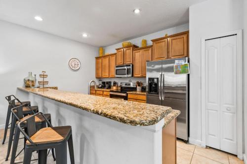 a kitchen with wooden cabinets and a granite counter top at Wonderful 4 bed Family Home with Private Pool in Kissimmee
