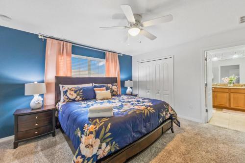 a blue bedroom with a bed and a ceiling fan at Wonderful 4 bed Family Home with Private Pool in Kissimmee