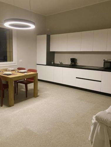 a kitchen with a wooden table and white cabinets at 292Bosco in Valeggio sul Mincio