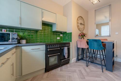 cocina con fogones y encimera con taburetes en Southport Rabbit Retreat, en Southport
