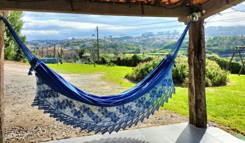 a blue hammock hanging from a pergola at Casa da Aldeia in Vilela