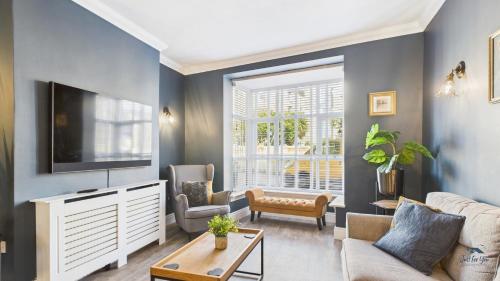 a living room with a couch and a tv at Simeon Sands Coastal Escape in Ryde