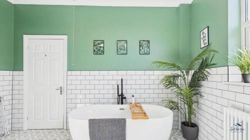 a bathroom with a white tub and green walls at Simeon Sands Coastal Escape in Ryde