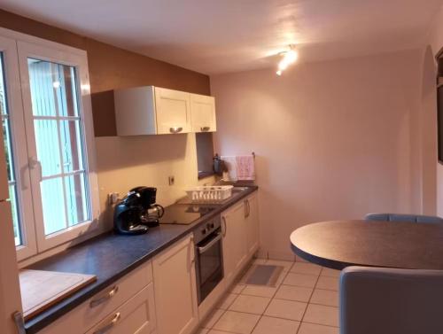 une cuisine avec un comptoir et une table à l'intérieur dans l'établissement Gîte du Marronnier, à Magné