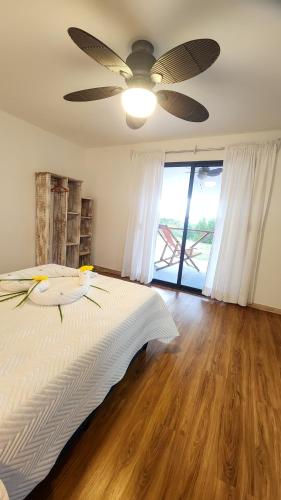 a bedroom with a bed with a ceiling fan at La Puesta del Sol B&B in Carrillo