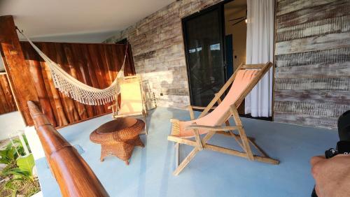 a hammock and a chair on a porch at La Puesta del Sol B&B in Carrillo