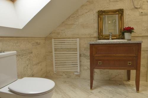 a bathroom with a toilet and a sink and a mirror at Kaštieľ Lodomeria Manor House in Lučenec