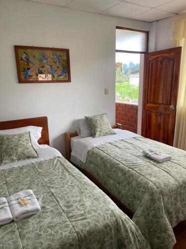 a bedroom with two beds and a window at Hospedaje Familiar Laos in Oxapampa