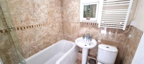 ein Badezimmer mit Waschbecken, Toilette und Badewanne in der Unterkunft Ocean's Eddge, Perranporth in Perranporth