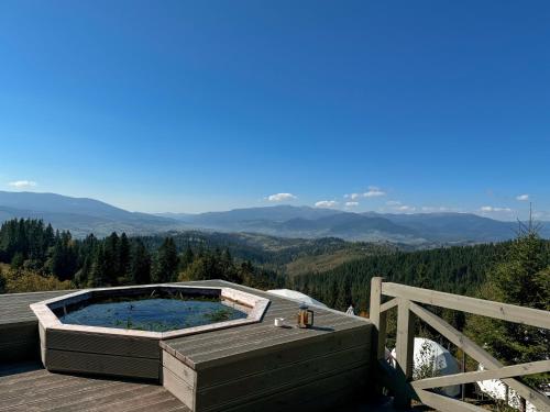a hot tub on a deck with mountains in the background at Charlton Estate in Yablunytsya