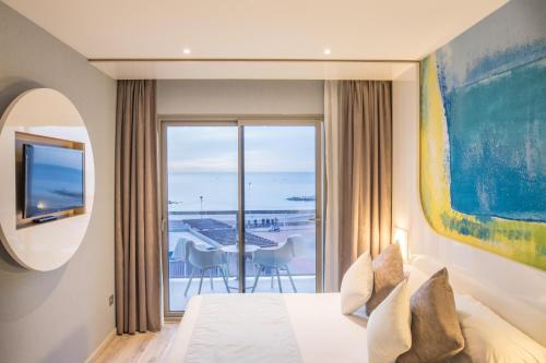 a bedroom with a bed and a view of the ocean at Hotel Vague d'or in Staoueli
