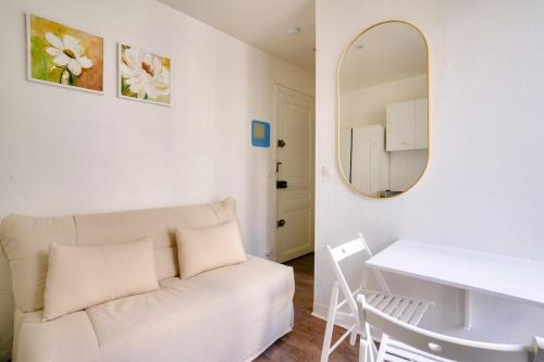 - un salon blanc avec un canapé blanc et un miroir dans l'établissement Cosy studio near The Eiffel Tower, à Paris