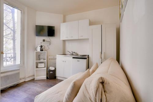 un salon avec un canapé et une cuisine dans l'établissement Cosy studio near The Eiffel Tower, à Paris