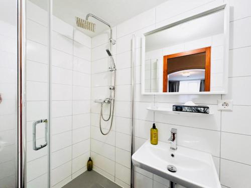 a white bathroom with a sink and a shower at Augustin Hotel und Restaurant Meersburg in Meersburg