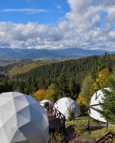 a group of three white tents in the woods at Charlton Estate in Yablunytsya
