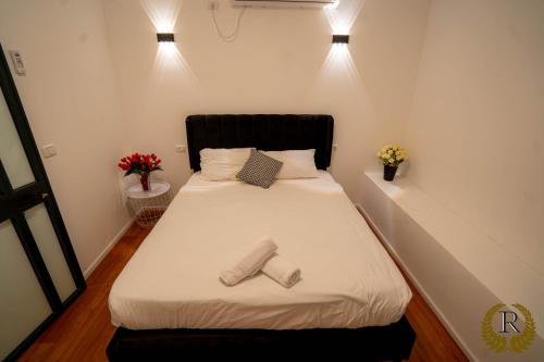 a bedroom with a bed with two shoes on it at Rich Boutique Hotel in Eilat