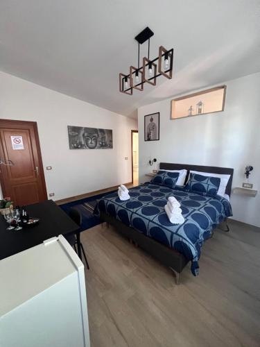 a bedroom with a bed with a blue comforter at ROSSI SUITE Fco in Isola Sacra