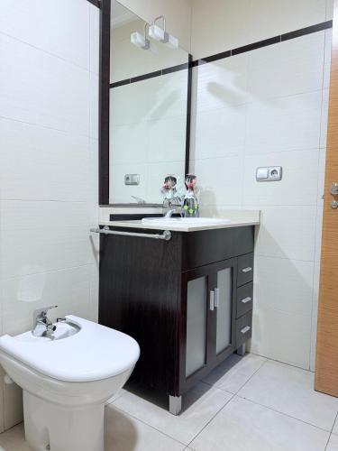 a bathroom with a sink and a toilet and a mirror at Alicante Hills 1 in Alicante