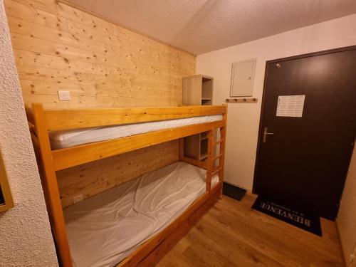Cette petite chambre comprend 2 lits superposés et une porte. dans l'établissement appartement près des pistes le refuge des Marmottes, à Les Deux Alpes