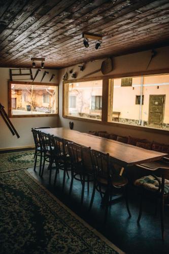 a large wooden table and chairs in a room with windows at Daheim in Râşnov