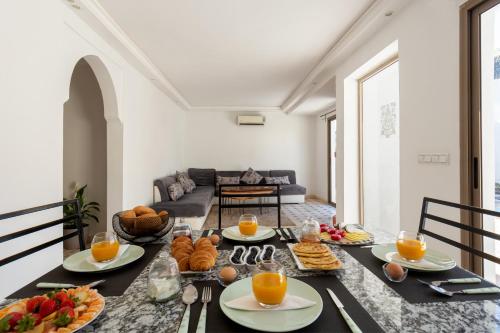 a dining room with a table with food and orange juice at Villa privée avec piscine Sans vis-à-vis, calme absolu in Marrakech