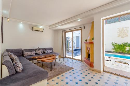 a living room with a couch and a table and a fireplace at Villa privée avec piscine Sans vis-à-vis, calme absolu in Marrakech