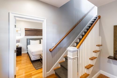 a bedroom with a bed and a stairway with a stair case at The Newport Lofts - 595 Thames Street in Newport