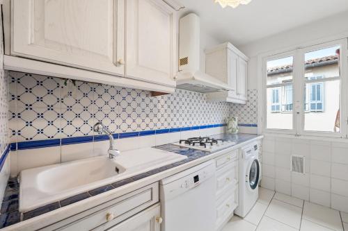 une cuisine blanche avec un évier et un lave-vaisselle dans l'établissement Rosalba - Vieux Nice, à Nice