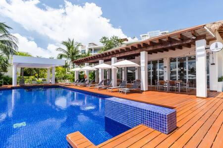 a swimming pool on a wooden deck next to a building at 2BR Apartment with Beach Club in Cancún