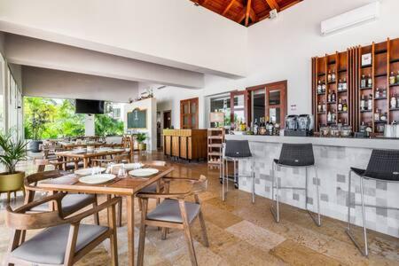 a restaurant with tables and chairs and a bar at 2BR Apartment with Beach Club in Cancún