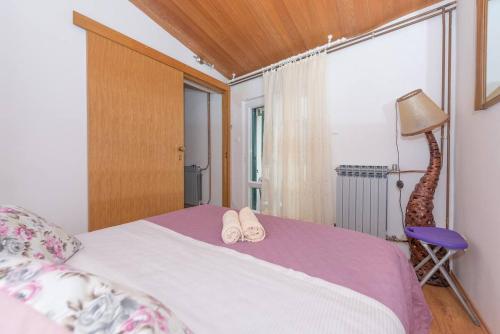 a bedroom with a bed with two slippers on it at Vera i Ćiro Novak 2, sea view and free parking in Brela
