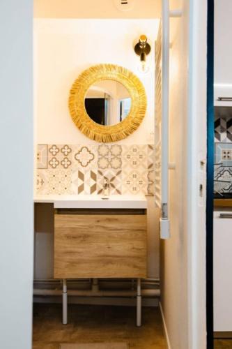 une salle de bain avec un miroir et un lavabo dans l'établissement Le Tilleul - Centre ville - Parking privé - Wifi, à Caen