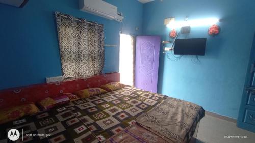 a bedroom with a bed and a window and a tv at Linga Classic Homes in Kanchipuram