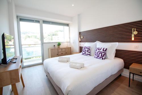 une chambre avec un grand lit blanc avec des oreillers violets dans l'établissement Luxury 1 Bed Apt Seafront Escape in Cannes, à Cannes