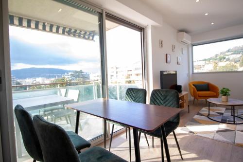 une salle à manger avec une table et des chaises et une grande fenêtre dans l'établissement Luxury 1 Bed Apt Seafront Escape in Cannes, à Cannes