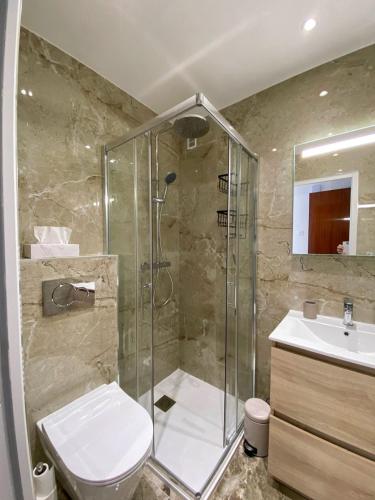une salle de bain avec une douche, des toilettes et un lavabo dans l'établissement Luxury 1 Bed Apt Seafront Escape in Cannes, à Cannes